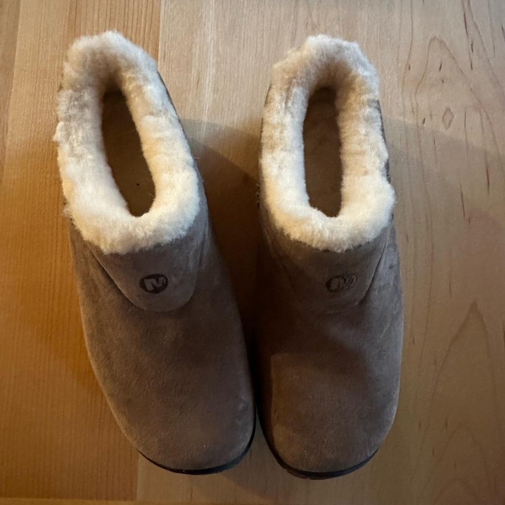 Beige Merrell slip-ons with creamy fleece lining.